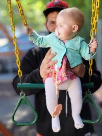 Little girl playing on swing at playground