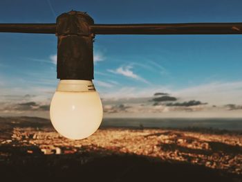 Close-up of light bulb on beach