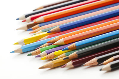 High angle view of colored pencils on white background