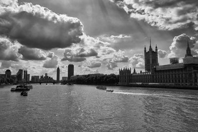 City at waterfront against cloudy sky