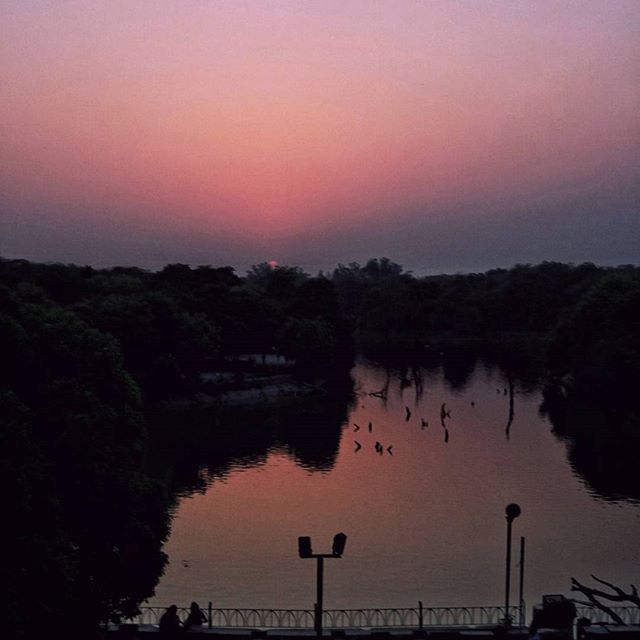 water, sunset, tranquil scene, tranquility, scenics, beauty in nature, silhouette, reflection, tree, nature, lake, sky, idyllic, dusk, river, calm, orange color, clear sky, outdoors, copy space