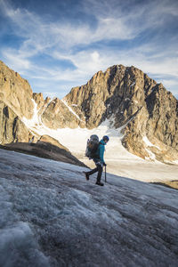 Full length of man on rock in mountains against sky