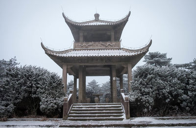 Low angle view of temple by building against sky