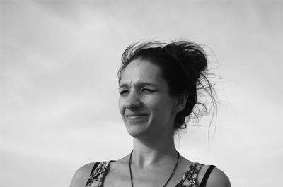 Portrait of a smiling young woman against sky