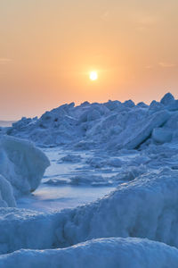 Scenic view of snowcapped landscape against sky during sunset