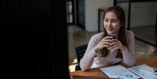 Portrait of young man using mobile phone at home