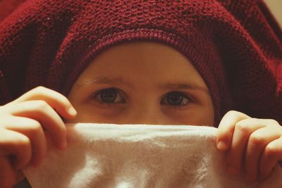 Close-up portrait of girl covering face with napkin