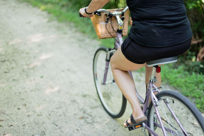 Low section of man riding bicycle on road