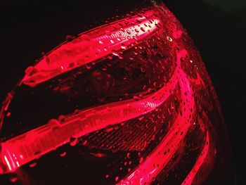 Close-up of red wine glass against black background