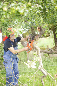 Senior man with chainshaw in garden