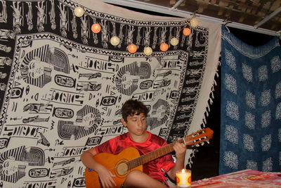 Full length of a boy playing guitar