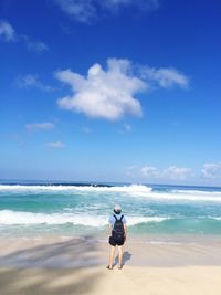 Rear view of person standing on sand at beach