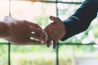 Close-up of hand holding hands against blurred background