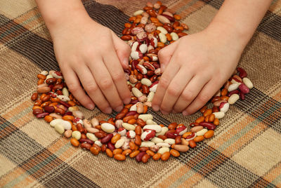 Cropped hands of person holding nut food on table