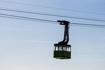 Low angle view of overhead cable car against sky