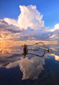 Man against cloudy sky during sunset