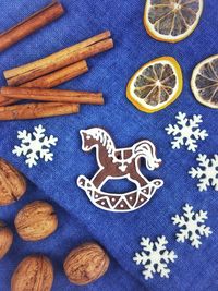 High angle view of gingerbread cookies with lemon and walnuts by cinnamon on table