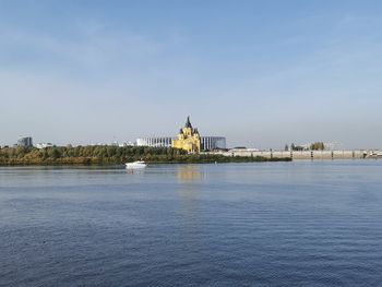 View of building by river against sky in city