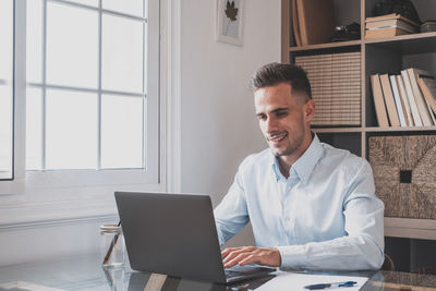 Young businesswoman using laptop at home