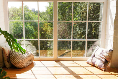 Cozy window sill with monstera and pillows indoors. sunlights in home