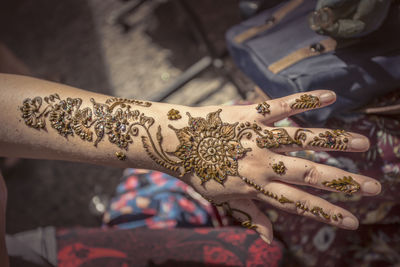 Cropped hand of woman with heena tattoo