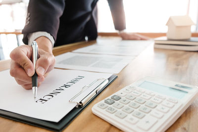 Midsection of man with text on table