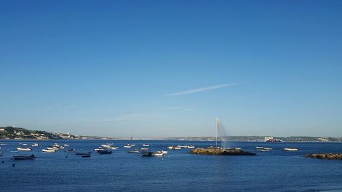 Sailboats in sea against blue sky