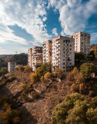 Buildings in city against cloudy sky