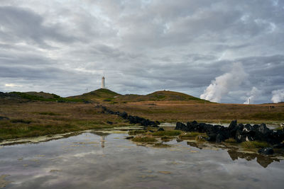 Scenic view of beacon on hill in cloudy day