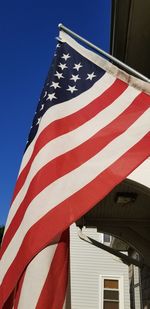 Low angle view of flag against blue sky