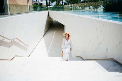 High angle view of woman standing by swimming pool