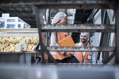 Smiling man and woman in food processing plant