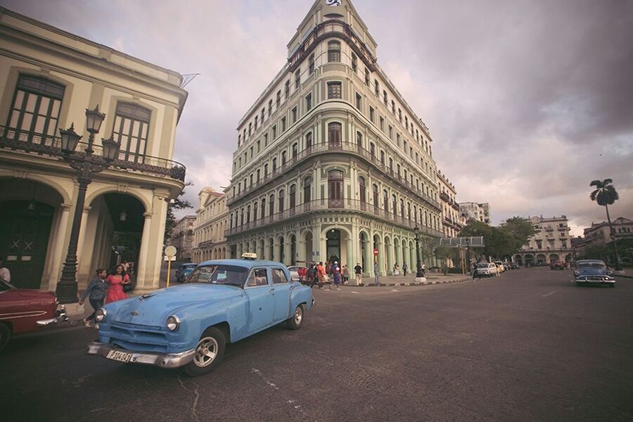 building exterior, architecture, built structure, transportation, car, land vehicle, mode of transport, street, city, sky, road, incidental people, city street, cloud - sky, travel, building, city life, cloud, travel destinations, person