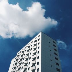 Low angle view of modern building against cloudy sky