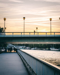 Bridge over river against sky during sunset