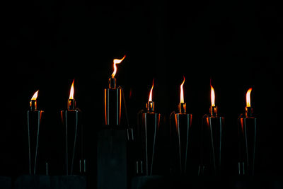 Close-up of illuminated cigarette lighters against black background