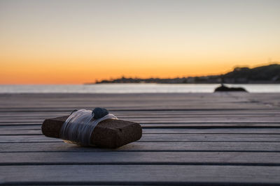 Close-up of wood on beach against sky during sunset