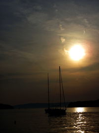 Sailboat sailing on sea against romantic sky at sunset