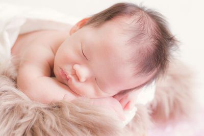 Close-up of baby girl sleeping on bed