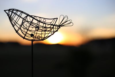 Silhouette bird shape artwork during sunset