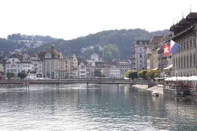 River by buildings in town against clear sky