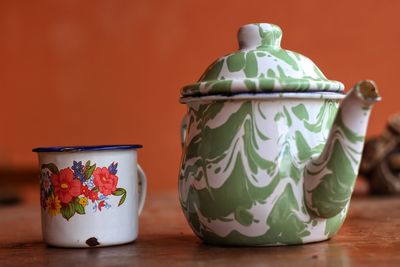 Close-up of teapot with mug on table