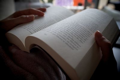 Midsection of person reading book