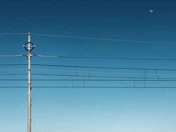 Low angle view of power lines against blue sky