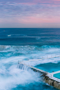 Scenic view of sea against cloudy sky during sunset