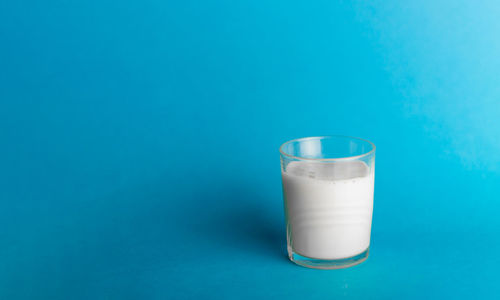 Close-up of water glass against blue background