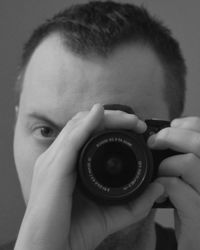 Close-up portrait of man photographing through camera