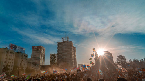 Crowd at music concert against sky