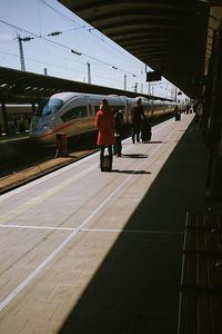 Man and woman on railroad station platform against sky