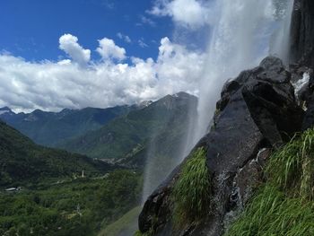 Scenic view of waterfall against sky